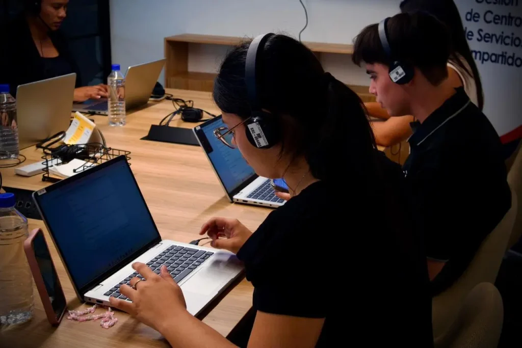Emprendedores trabajando en laptops durante una sesión de innovación y mentoría empresarial